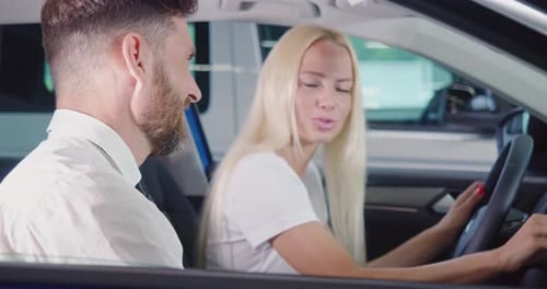 Man and Woman in a Car at Dealership
