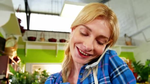 Woman Talking on Smartphone in Flower Shop