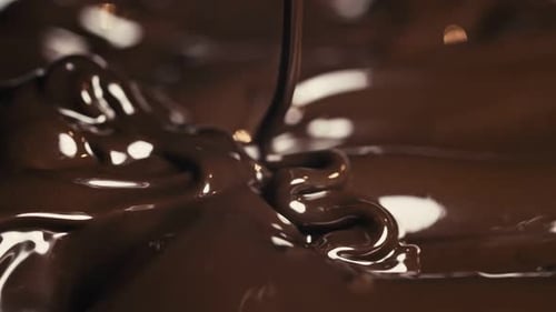 Chocolate. Pouring Melted Liquid Premium Dark Chocolate. Close Up of Molten Liquid Hot Chocolate