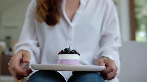 Young Adult Woman Eating Layered Cake Indoors