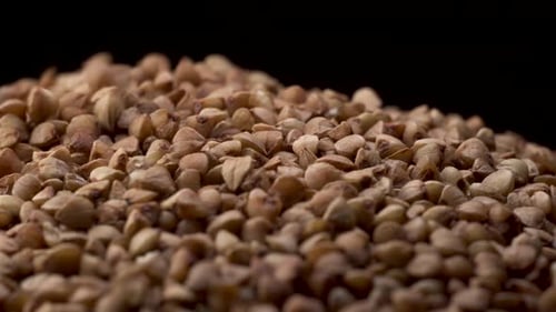 Rotating Macro Footage of Buckwheat with Falling Down on Black Table with Black Background