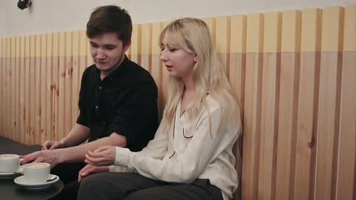 Young, Beautiful Couple Having a Date in Cafe, Talking and Drinking Coffee