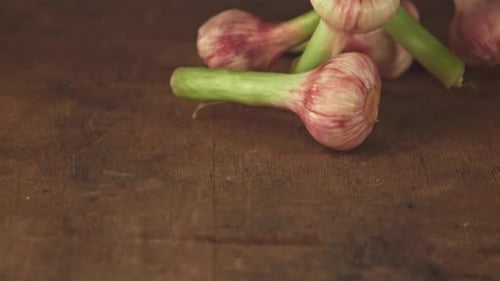 Super Slow Motion Garlic Falls on a Wooden Table