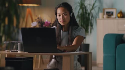 Woman Working from Home on Laptop with Headset