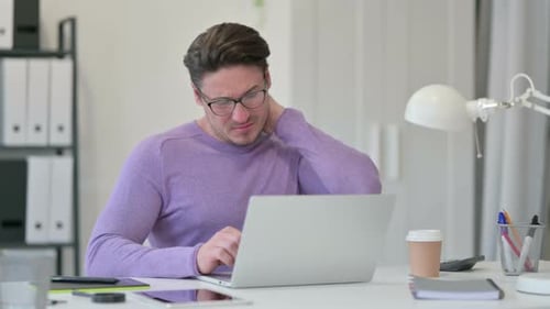 Middle Aged Man Having Neck Pain in Office