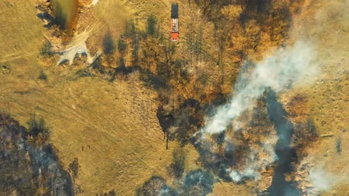 Firefighters Extinguish Burning Grass with Hoses Aerial View