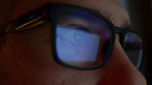Man with Glasses Working at a Computer Stock Market Analytics