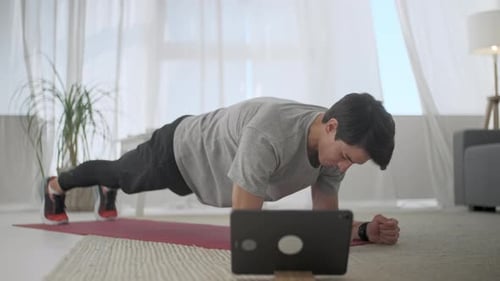 Young Adult Man Doing Plank Exercise at Home