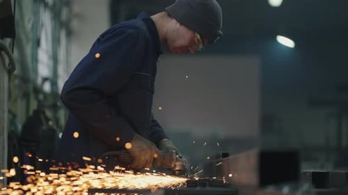 Ein Mann in Schutzbrille arbeitet mit Metallschleifen, Polieren und Abisolieren von Stahlmetallkonstruktionen.