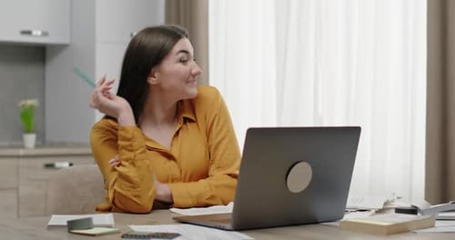 Contemplative Woman with Laptop Thinks at Desk