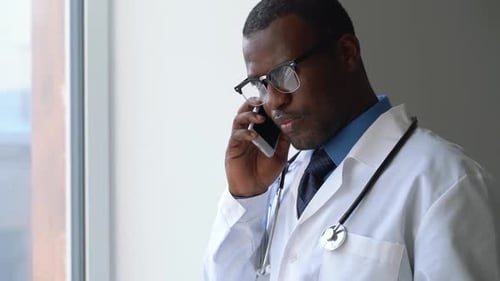 Doctor in Uniform Coat Talk on Phone in Workplace Hospital