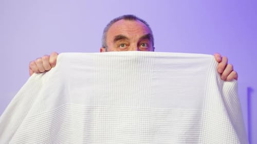 Man with Gray Hair Hiding Behind Blanket