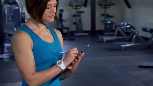 Fitness-Frau posiert im Fitnessstudio