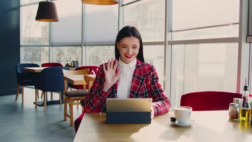 Young Woman Video Calling on Tablet in Restaurant