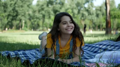 Une petite et très belle fille allongée sur l'herbe, souriant sincèrement