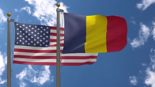 Two National Flags Waving in Wind Against Blue Sky