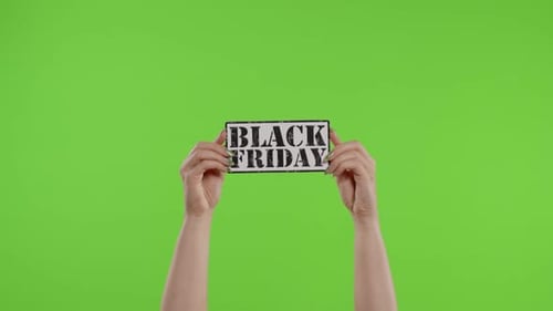 Black Friday Advertisement Inscription on Paper Sheet in Womans Hands on Chroma Key. Slow Motion
