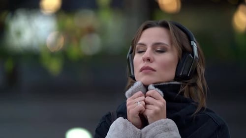 Adult Melancholy Woman with Headphones on Street at Cold Autumn Day, Female Portrait, Listening To