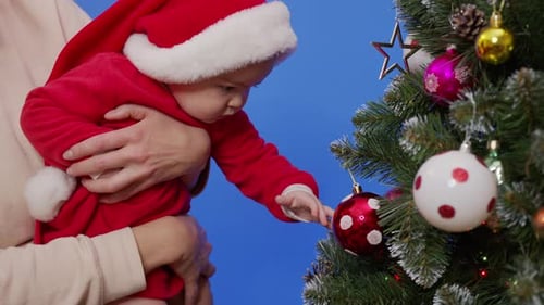Adorable Baby Reaches for Christmas Tree Ornament