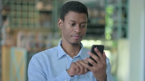 Young Adult Using Smartphone Device Indoors