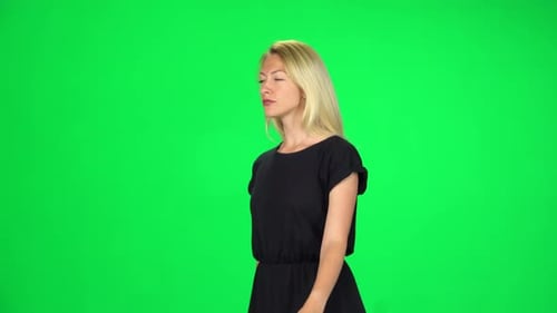 Pensive Girl Is Walking on a Green Screen at Studio.