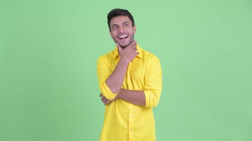 Happy Young Hispanic Businessman Thinking and Looking Up