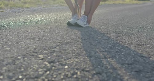 Woman Stretching Leg Muscles Before Exercise on Road