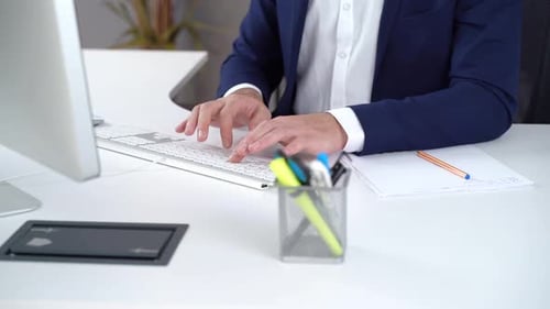 Office worker in suit using computer.