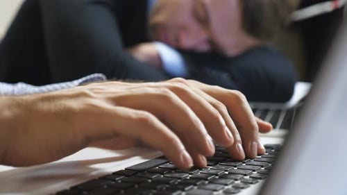 Close Up to Arms of Young Manager Typing Text on Laptop Keyboard at Office