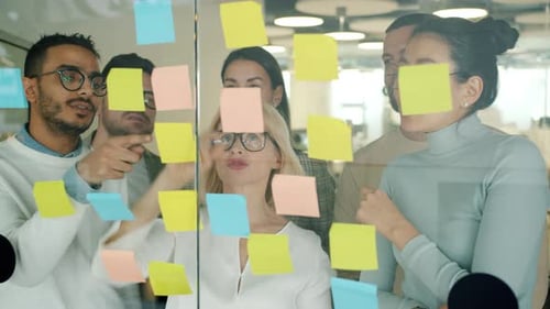 Creative Team Brainstorming with Sticky Notes in Office