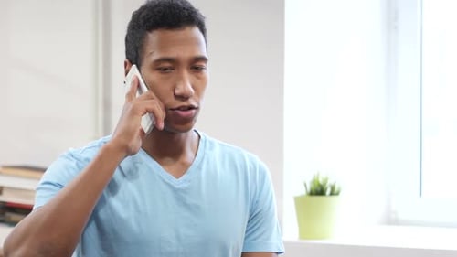 Young Adult Talking on the Phone Indoors