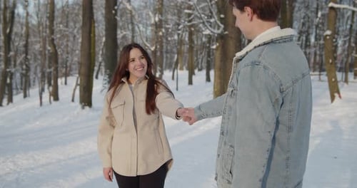 Happy Young Beautiful Couple Spend Time in Sunny Winter Forest Together