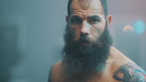 Intense Bearded Man with Tattoo Stares into Camera