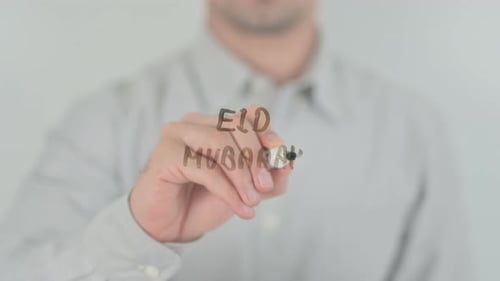Writing Eid Mubarak with Marker on Clear Surface