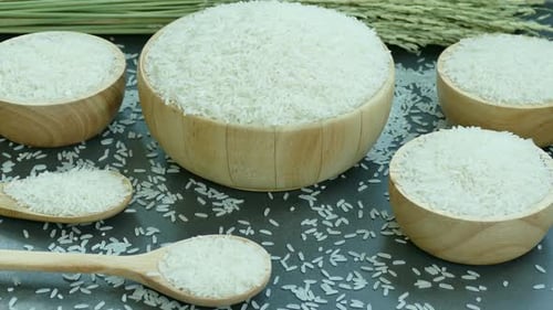Abundant White Rice in Wooden Bowls and Spoons
