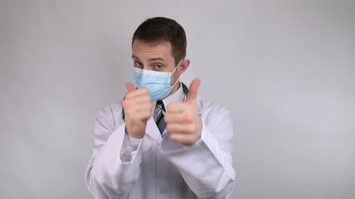 Der Doktor in der Maske zeigt Daumen hoch