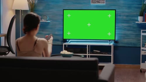 Adulto joven viendo pantalla verde en la televisión