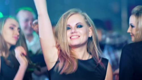 Schöne blonde Frau tanzt auf einer Party