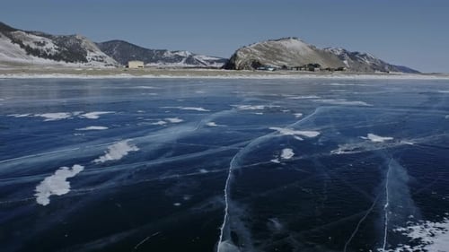 Clear Ice on Baikal Lake and Village