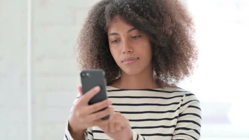 Young Woman with Curly Hair Using a Phone