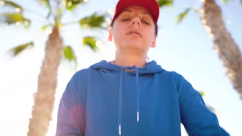 Woman Using Smartwatch Outdoors in Tropical Setting