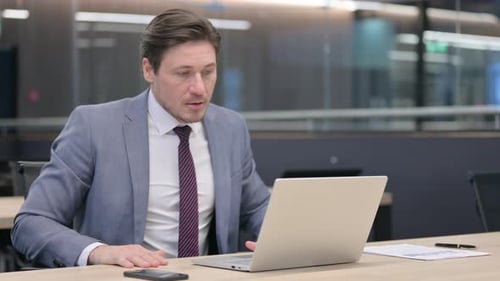 Man in Suit Working at Laptop in Office