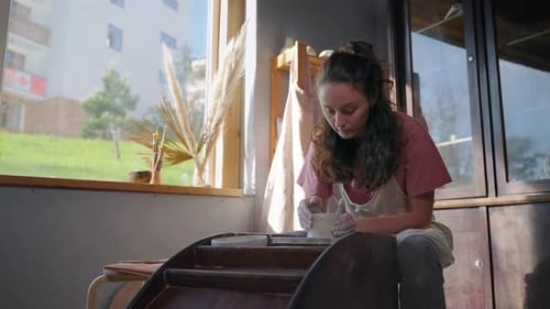 Female Potter is Making Ceramic Pot on Pottery Wheel in Workshop