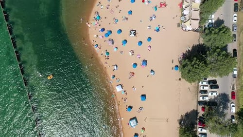 Colorful Kayaks And Parasols On Sandy Beach In Summer. aerial top-down