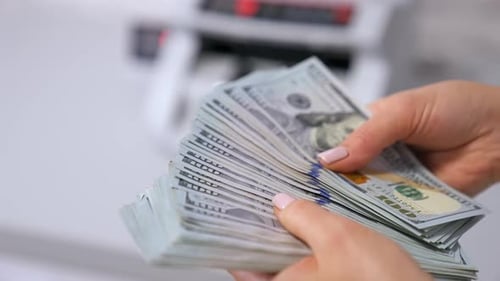 Counting Money with a Money Counter in Background