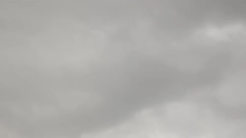 Grey rainy stormy clouds moving fast against sky.