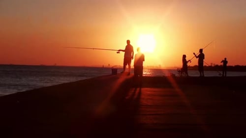 Silhouettes of Fishermen on Pier at Sunset