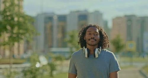 Happy Darkskinned Guy Walks Through the Streets of the City