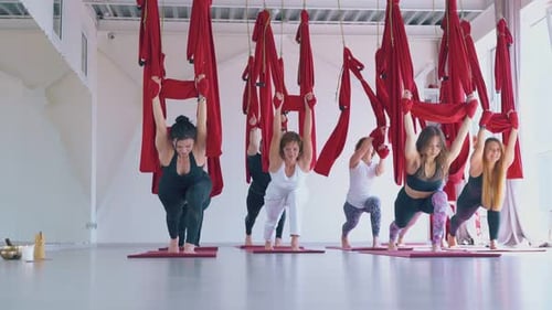 People Exercising with Aerial Yoga in Studio