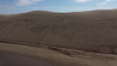 Aerial footage of a huge sand dune on the shore of the Atlantic ocean